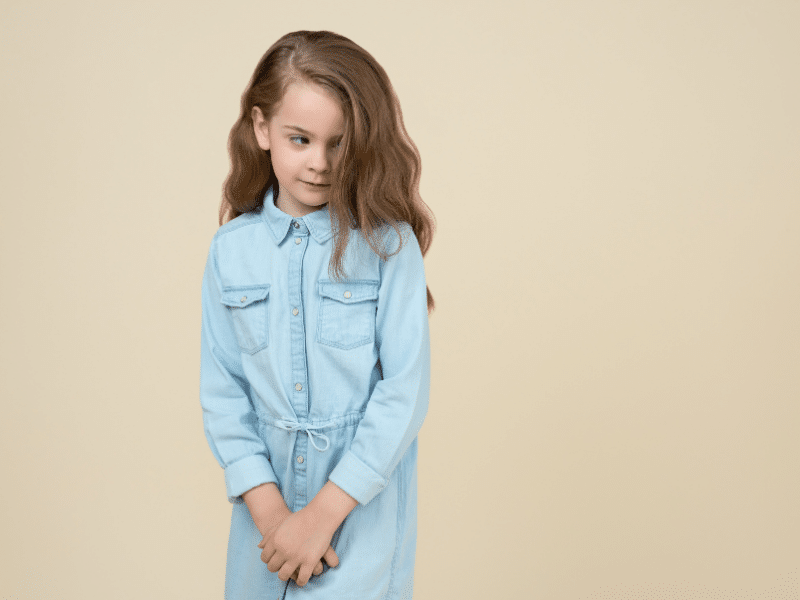 Utangaç davranış sergileyen ve annesine yakın duran küçük çocuk